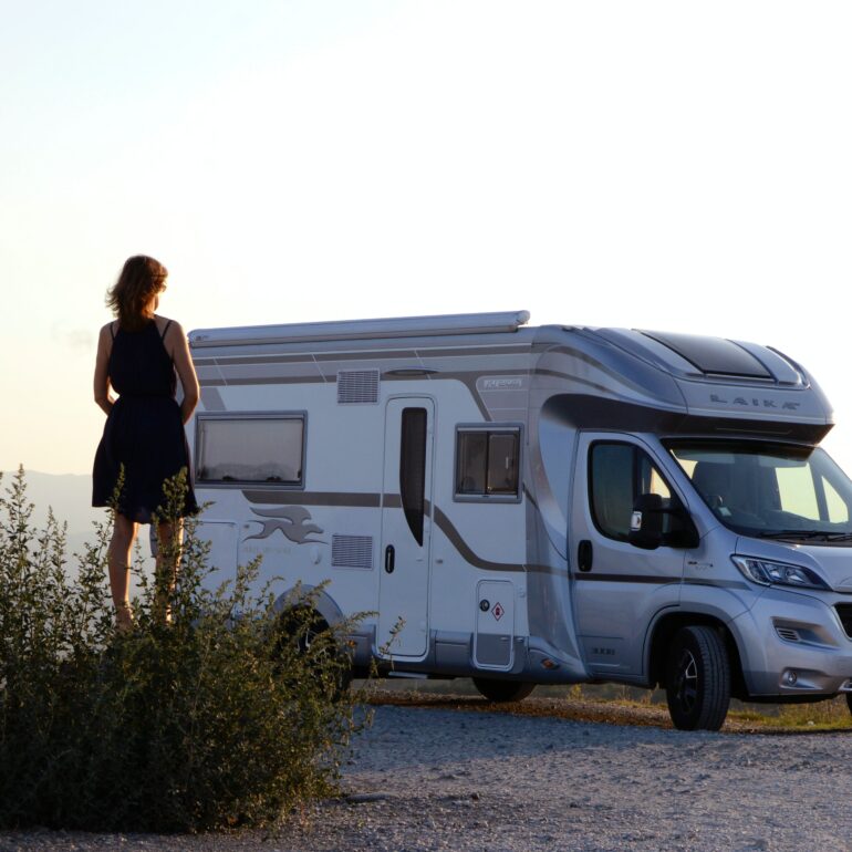 Femme de dos et debout qui regarde son camping-car